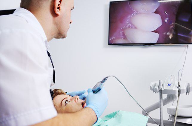 Dentist using intraoral camera to show patient her smile