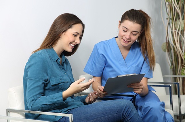 Dental team member talking to patient about dental treatment options