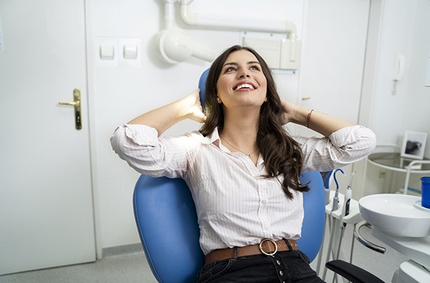 La mujer se siente relajada mientras está sentado en el sillón dental