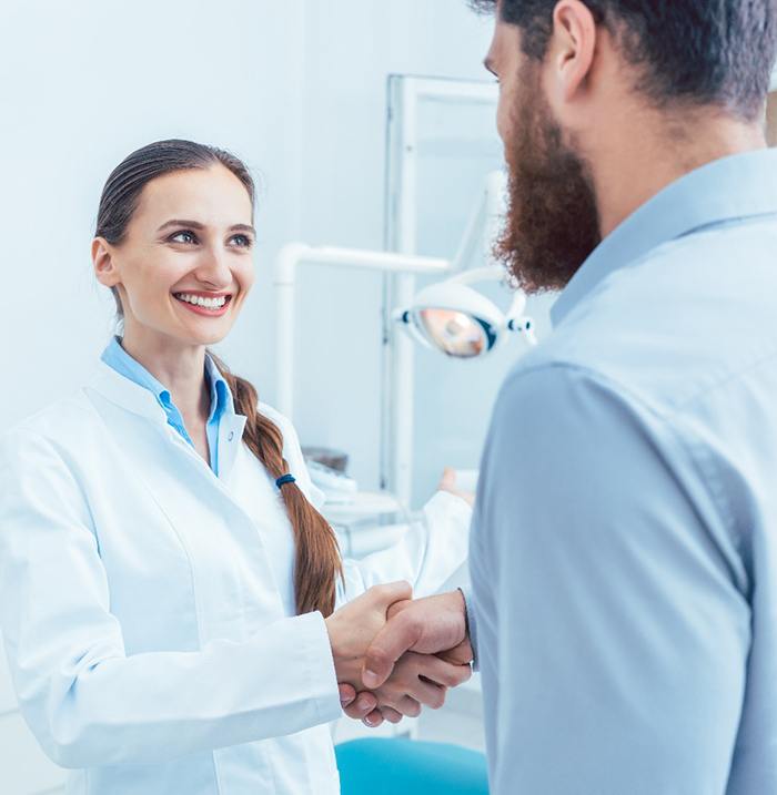 Paciente un apretón de manos con el dentista en el consultorio dental