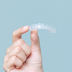 Closeup of Invisalign aligner being held by patient