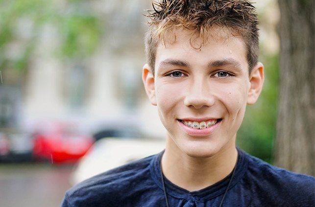 Young man receiving traditional orthodontics treatment