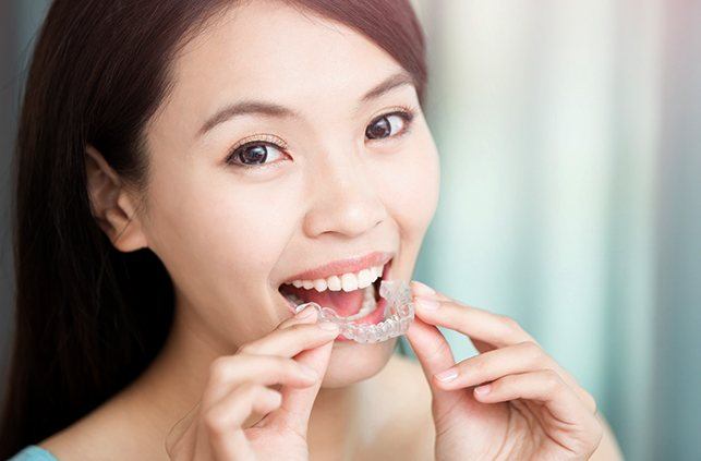 Woman placing Invisalign tray