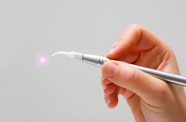 Hand holding a soft tissue laser therapy tool