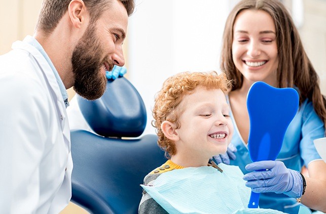 Young boy looking at smile during children's dentistry visit