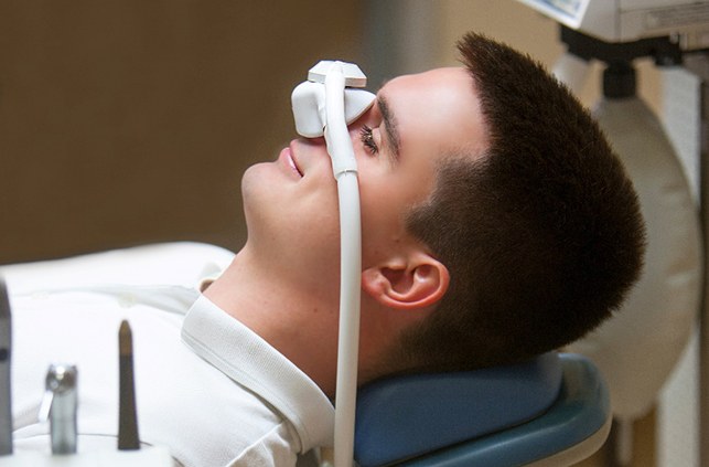Man smiling while breathing in nitrous oxide at dental office