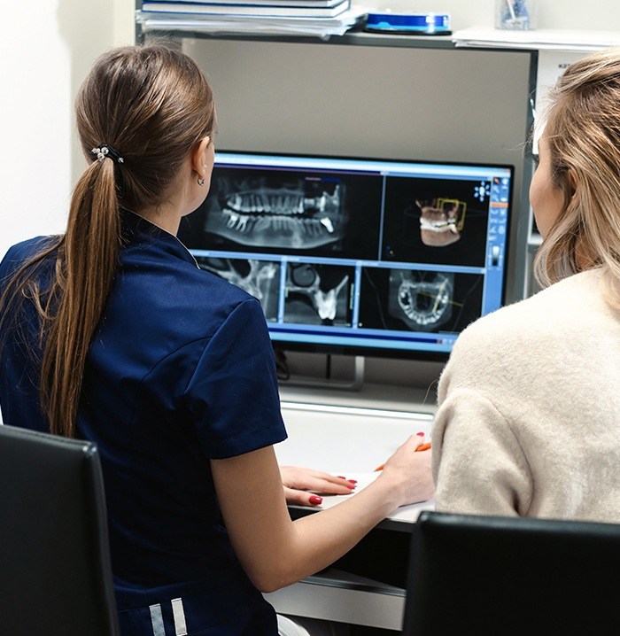 Two dental team members looking at digital x-rays