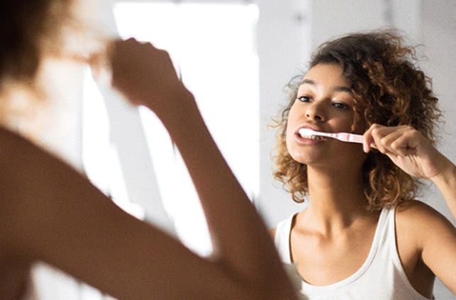 Closeup of woman brushing her teeth