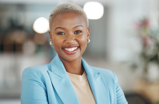 Woman in blue blazer smiling at office