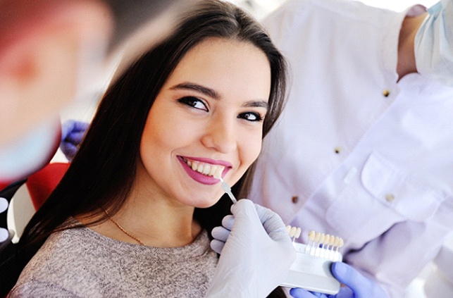 Woman smiling at dentist during veneers consultation