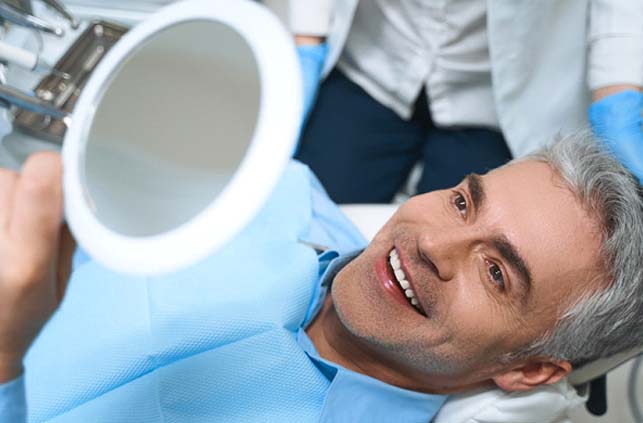 Patient and dentist smile and discuss the cost of veneers in Fitchburg