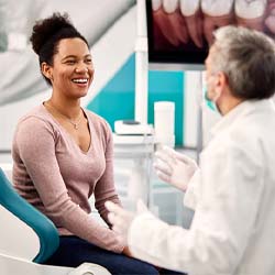 Receptionist and patient discussing how to pay for veneers in Fitchburg