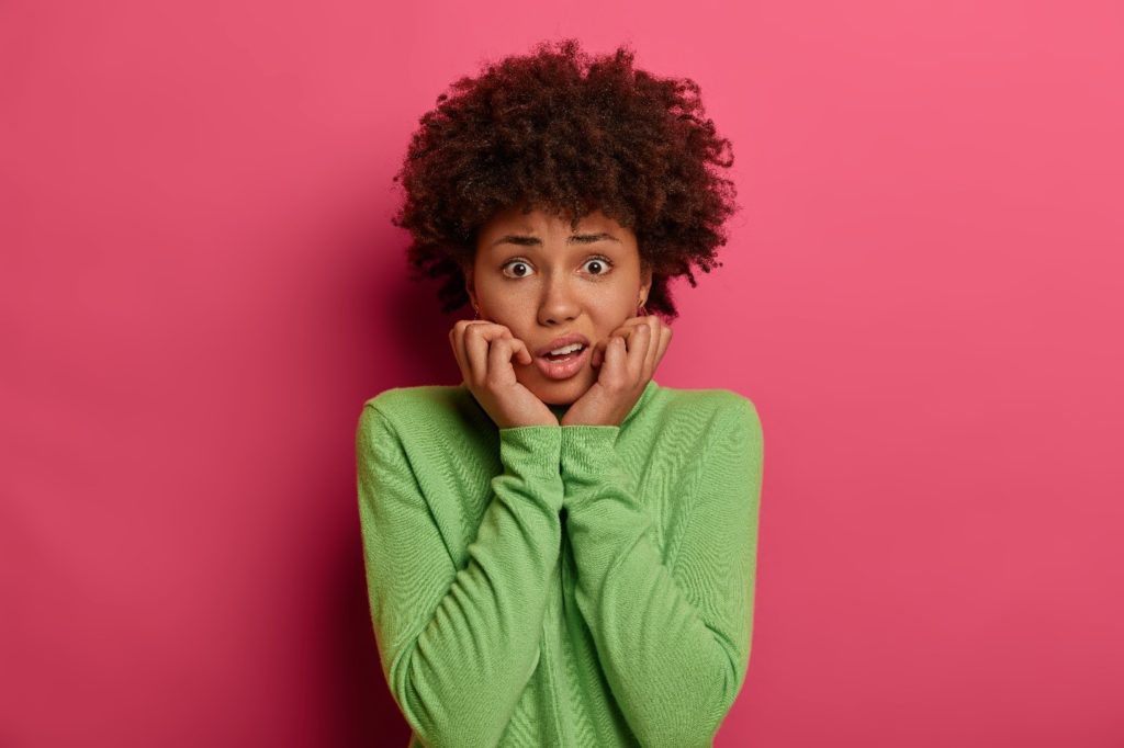 Closeup of woman in green shirt looking worried