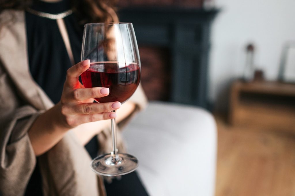 Closeup of patient holding glass of wine