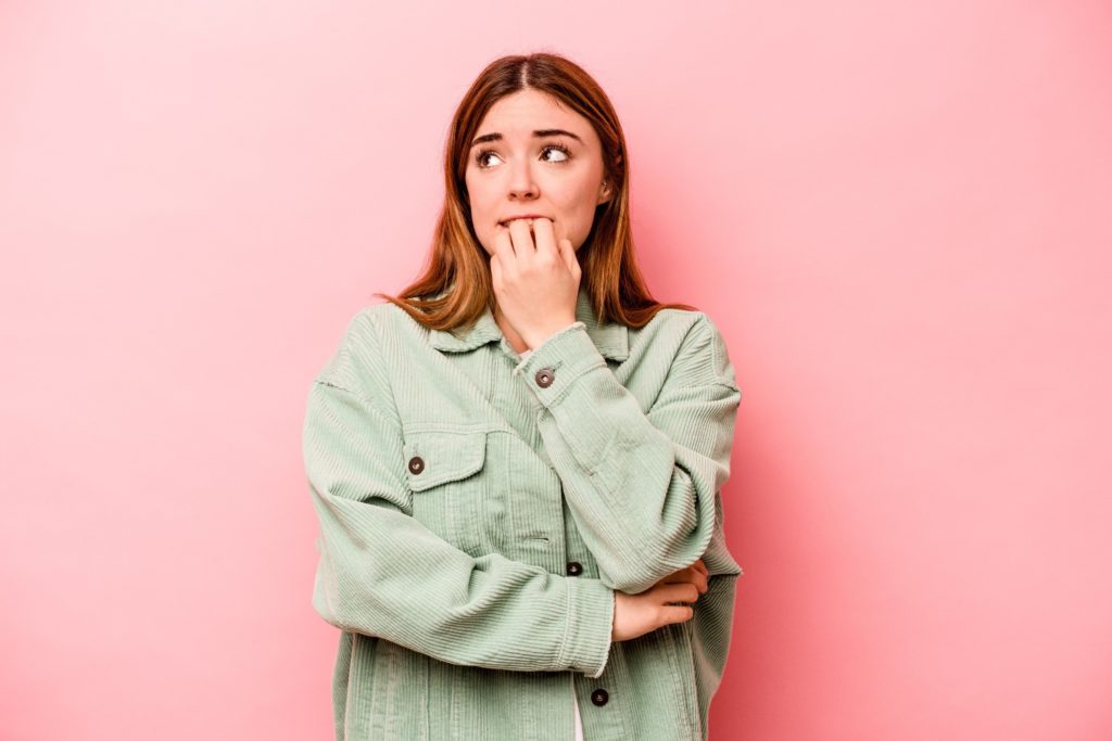 Closeup of woman in sage jacket looking nervous